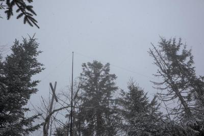 Gipfelkreuz und Antenne im starken Schneetreiben